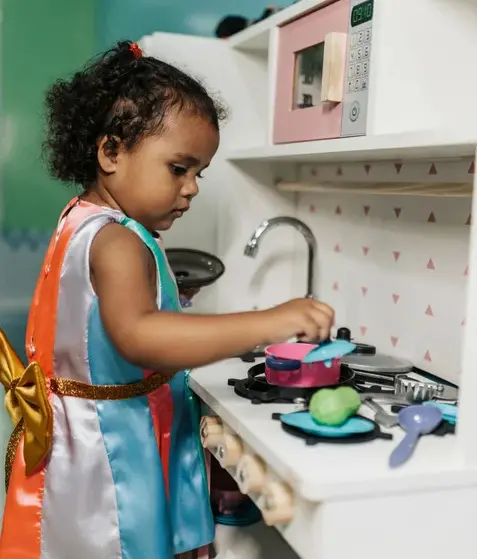 Child Playing With Pretend Cook Stove