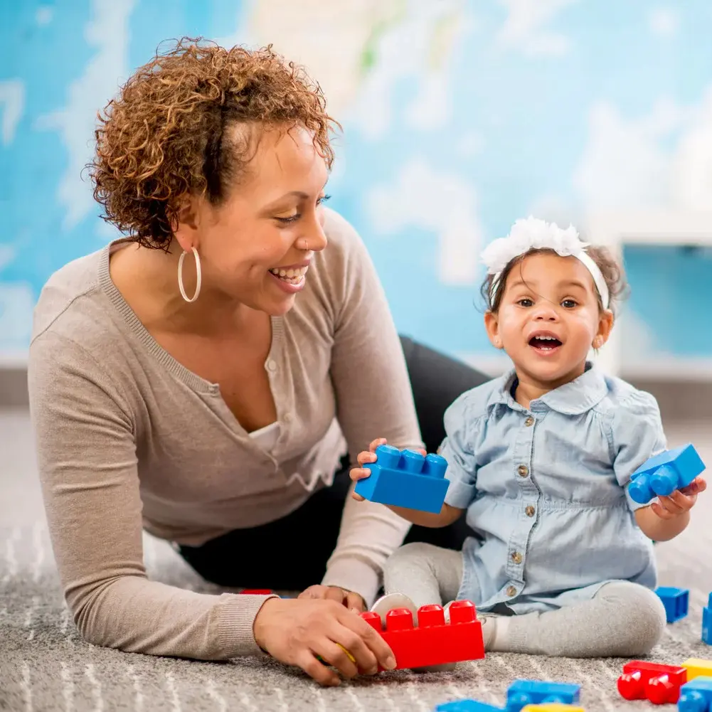 Testimonial 5 Care Giver Playing With Infant And Blocks