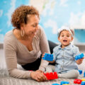 Testimonial 5 Care Giver Playing With Infant And Blocks